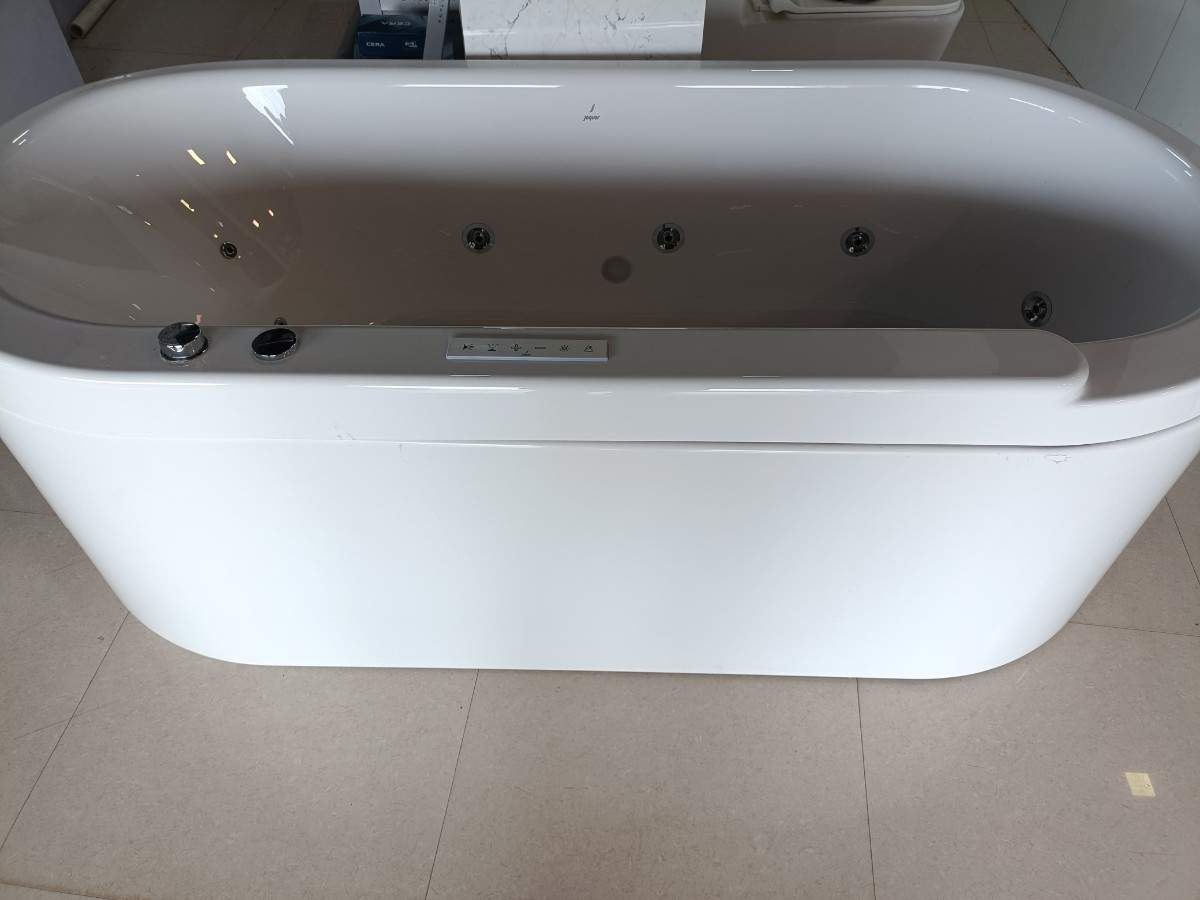 Freestanding bathtub, likely with jacuzzi or whirlpool features given the visible jets and controls